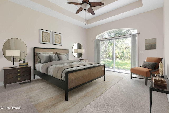 carpeted bedroom featuring access to outside, ceiling fan, and a tray ceiling