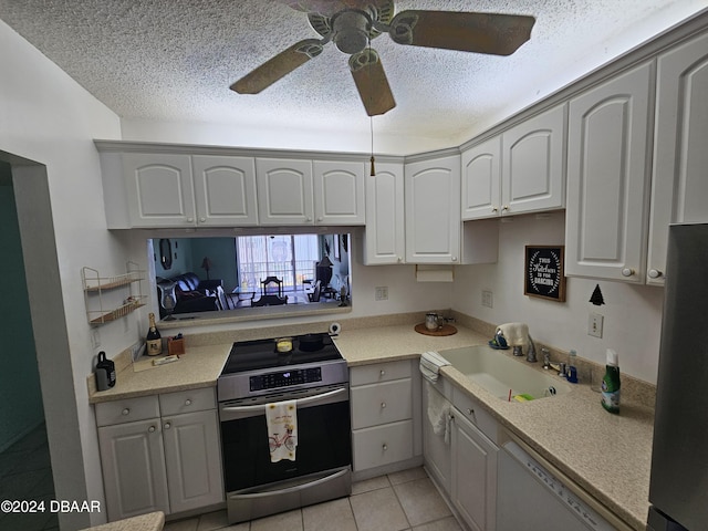 kitchen featuring sink, gray cabinets, a textured ceiling, appliances with stainless steel finishes, and light tile patterned flooring