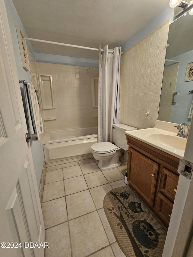 full bathroom with vanity, shower / bath combo with shower curtain, tile walls, tile patterned flooring, and toilet