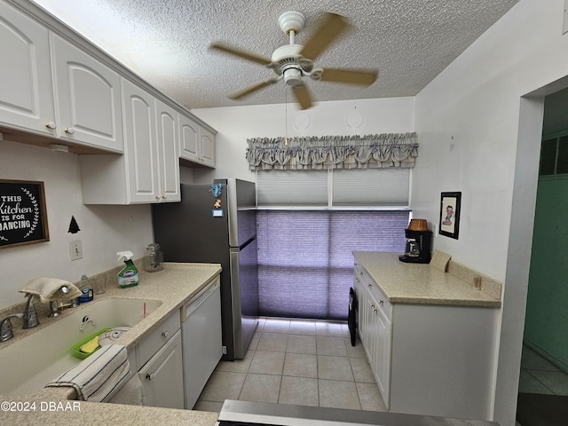 kitchen with white cabinets, a textured ceiling, sink, light tile patterned floors, and dishwasher