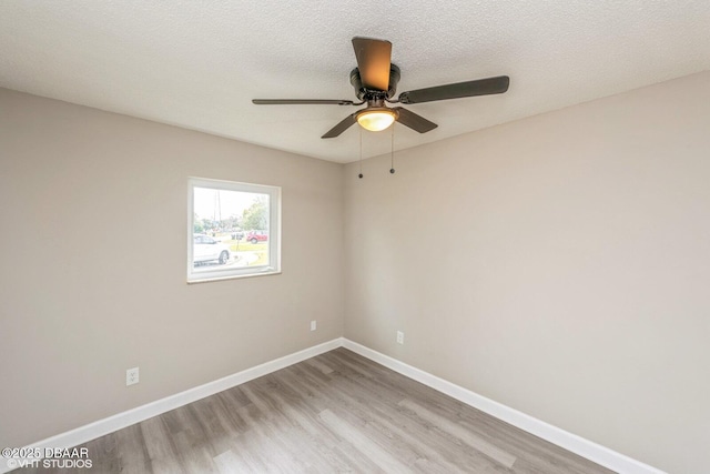 spare room with ceiling fan, a textured ceiling, and light wood-type flooring