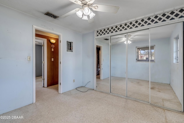 unfurnished bedroom with ceiling fan and a closet