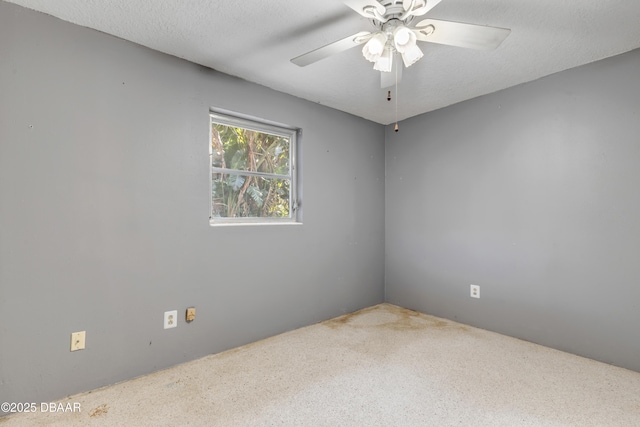 empty room with ceiling fan and a textured ceiling