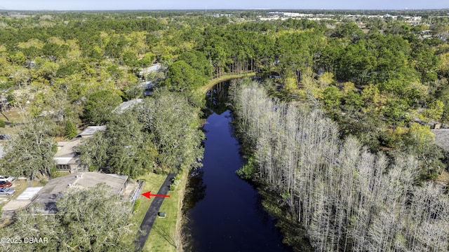 drone / aerial view with a forest view and a water view