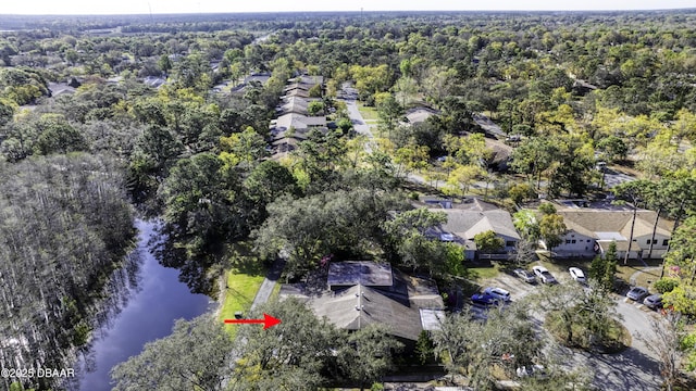 drone / aerial view with a forest view and a water view