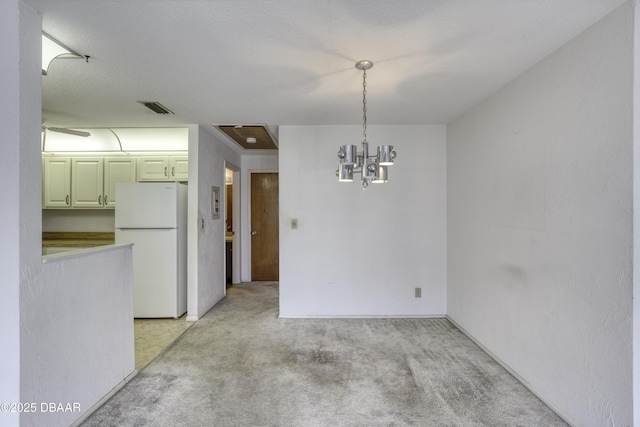 unfurnished dining area with light carpet, visible vents, and a chandelier