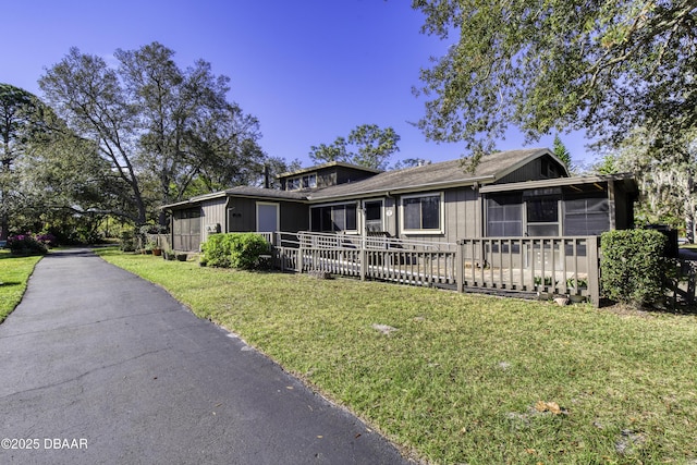 single story home with a front lawn and a sunroom