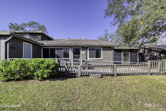 back of property with a yard and a sunroom