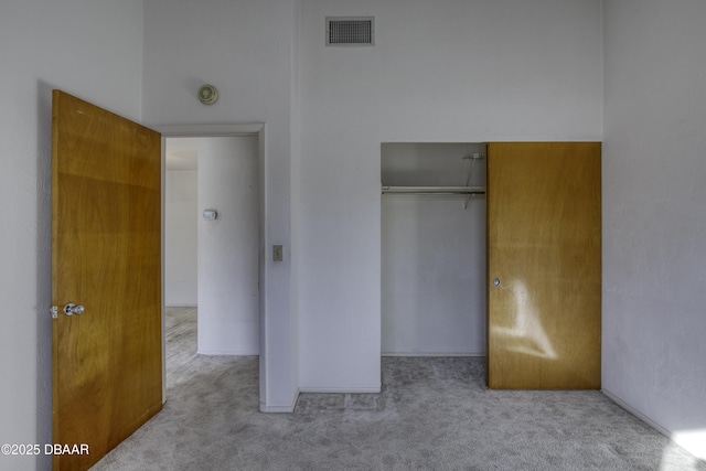 unfurnished bedroom featuring a closet, visible vents, and carpet flooring