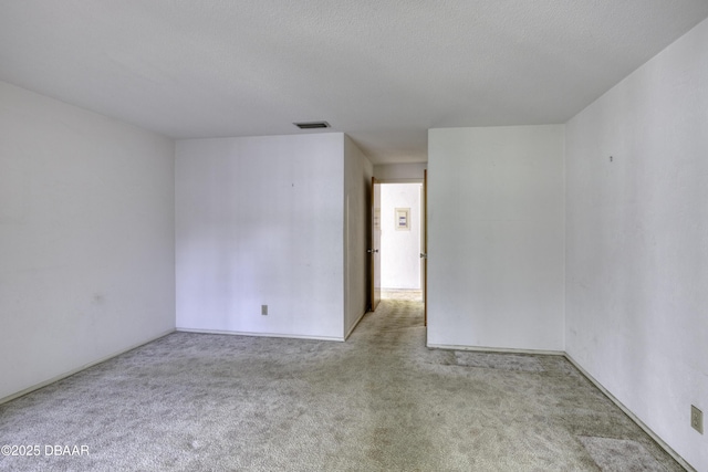 carpeted empty room featuring visible vents and a textured ceiling