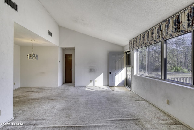 empty room with carpet flooring, lofted ceiling, a notable chandelier, and visible vents