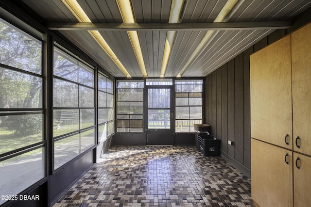 unfurnished sunroom with beam ceiling