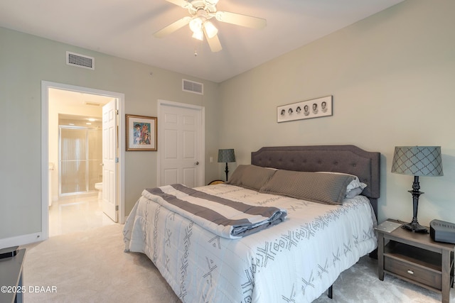 bedroom featuring visible vents, light colored carpet, and ensuite bath