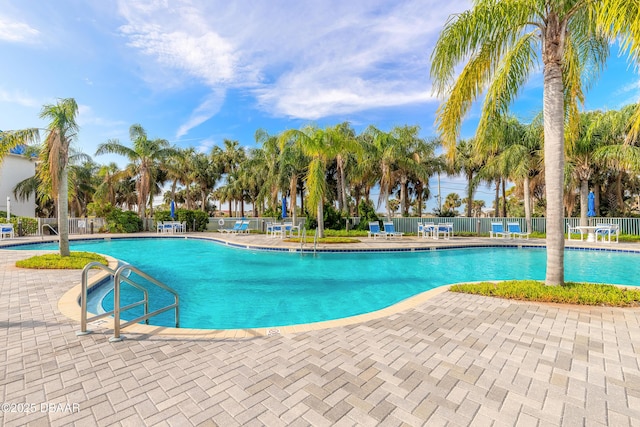 community pool featuring fence and a patio