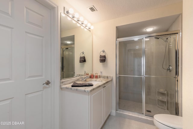 bathroom with visible vents, toilet, a stall shower, a textured ceiling, and vanity