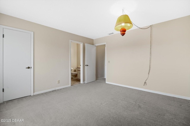 unfurnished bedroom featuring carpet flooring and connected bathroom