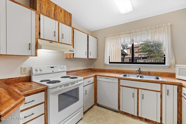 kitchen featuring white appliances, sink, a textured ceiling, and white cabinets