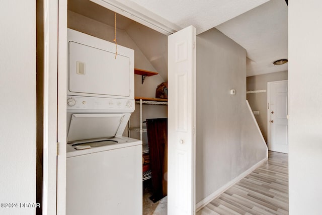 laundry area featuring light hardwood / wood-style floors and stacked washer / dryer