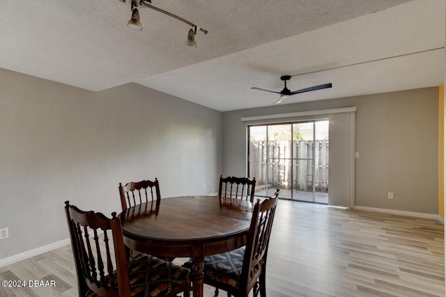 dining space featuring a textured ceiling, light wood-type flooring, and ceiling fan