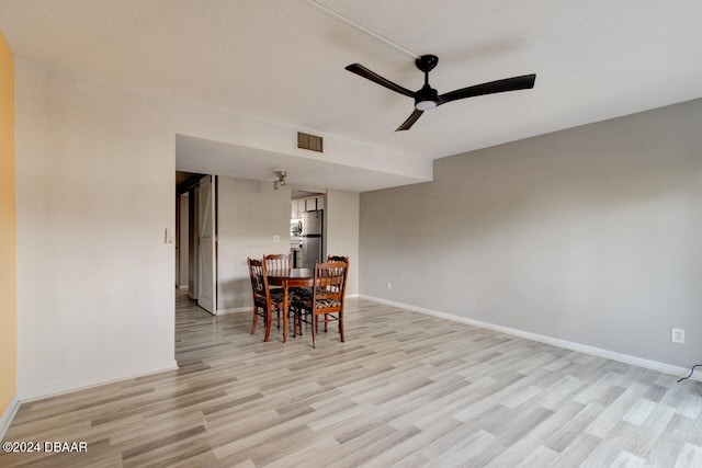 dining space with a textured ceiling, light hardwood / wood-style flooring, and ceiling fan