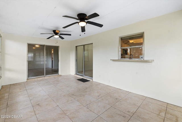 empty room featuring sink, light tile patterned floors, and ceiling fan