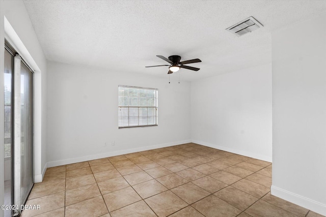 empty room featuring ceiling fan, a textured ceiling, and light tile patterned floors