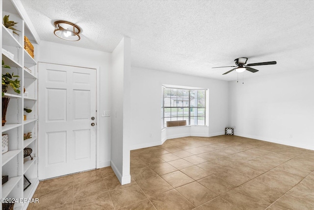 entrance foyer featuring a textured ceiling, ceiling fan, and light tile patterned flooring