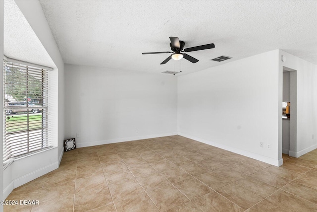 spare room featuring ceiling fan, a textured ceiling, and light tile patterned floors