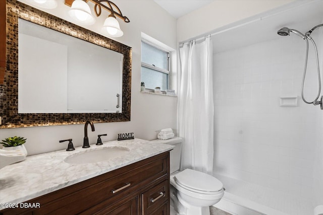 bathroom featuring toilet, vanity, and walk in shower