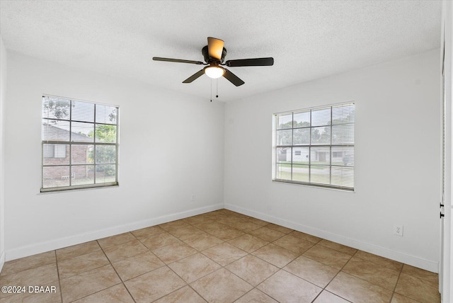 tiled empty room with ceiling fan and a textured ceiling