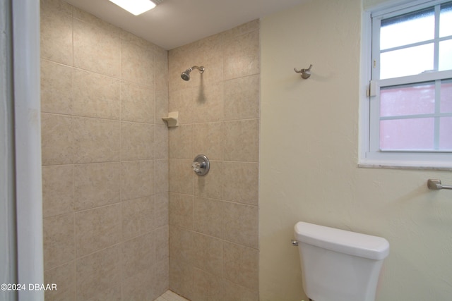 bathroom featuring toilet and tiled shower