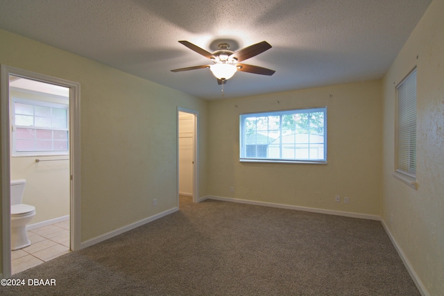 carpeted spare room featuring ceiling fan and a textured ceiling