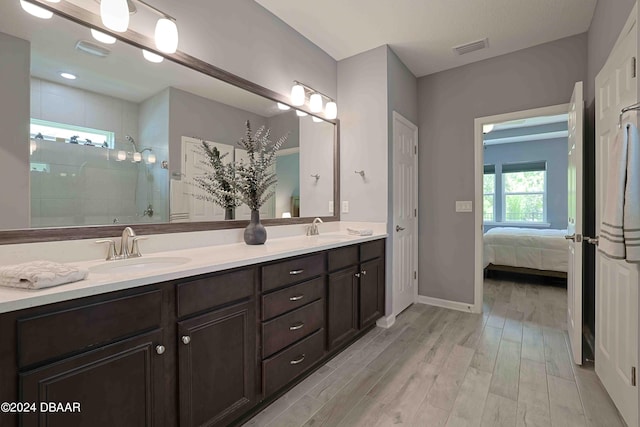 bathroom with walk in shower, wood-type flooring, and vanity