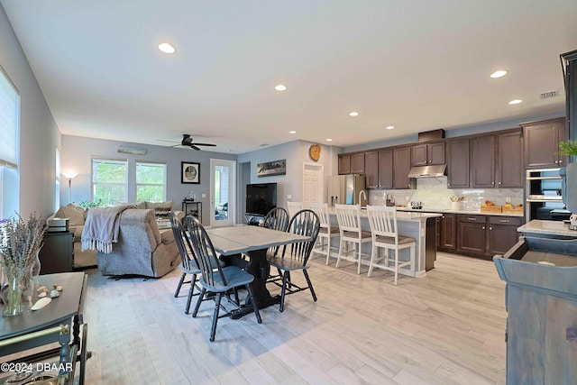 dining space with light hardwood / wood-style floors and ceiling fan