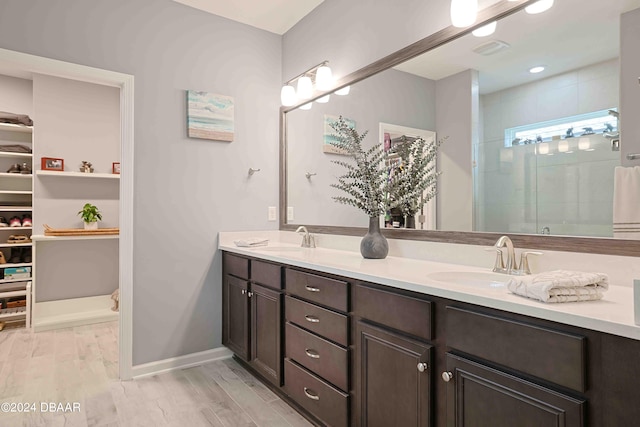 bathroom featuring wood-type flooring, vanity, and an enclosed shower