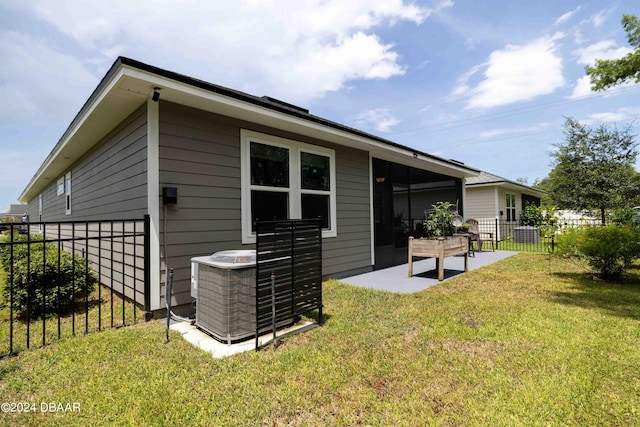 rear view of house featuring a patio, a lawn, and cooling unit