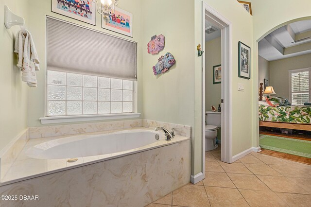 bathroom featuring tile patterned floors, a tub, and toilet