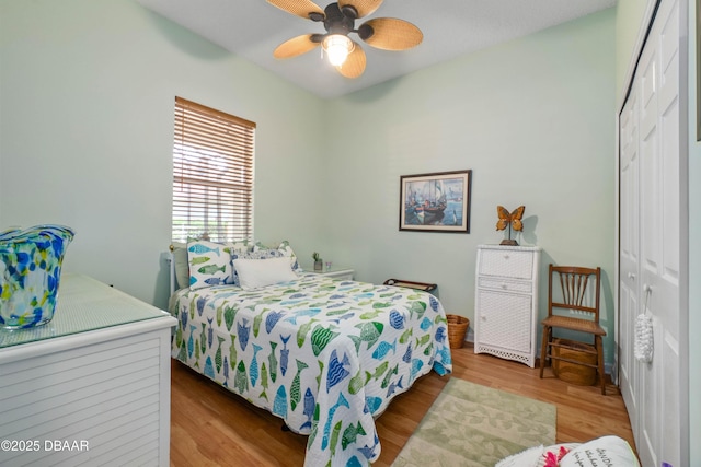 bedroom featuring light hardwood / wood-style floors, ceiling fan, and a closet