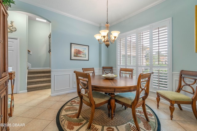 tiled dining room featuring crown molding and a notable chandelier