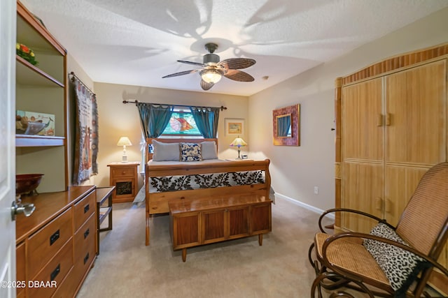 bedroom with light colored carpet, a textured ceiling, and ceiling fan