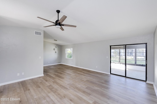 empty room with light hardwood / wood-style floors, lofted ceiling, and ceiling fan with notable chandelier