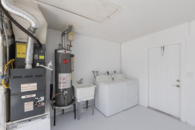 clothes washing area featuring sink, heating unit, water heater, and washing machine and clothes dryer