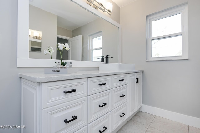 bathroom with a wealth of natural light, tile patterned floors, and vanity