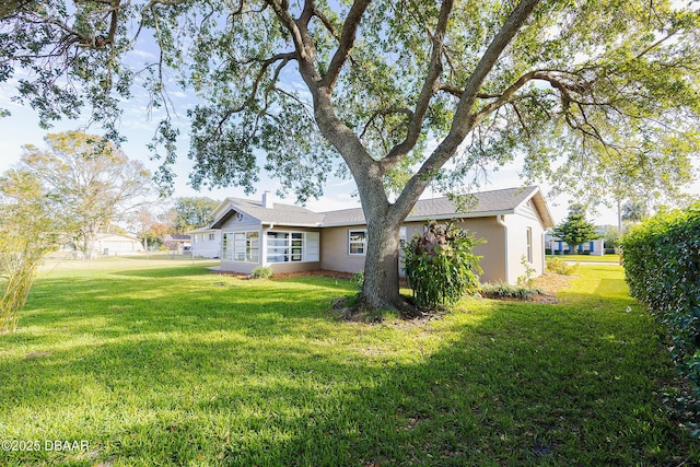 back of property with a lawn