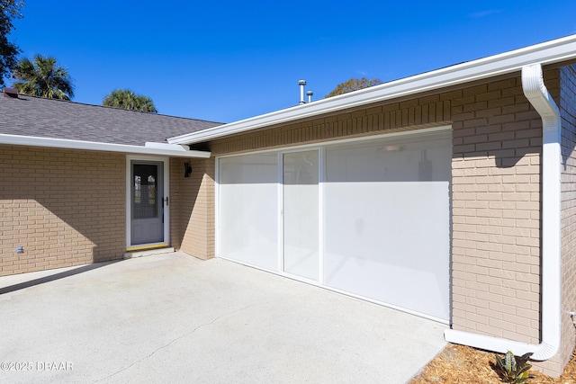 doorway to property with a garage and a patio area