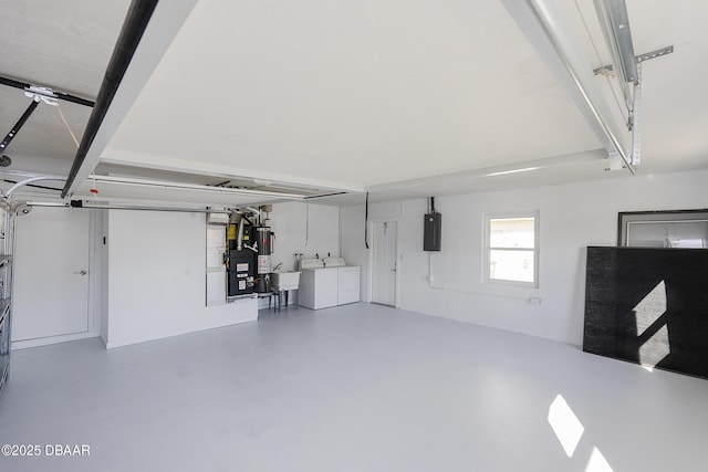 garage featuring separate washer and dryer, electric panel, and sink