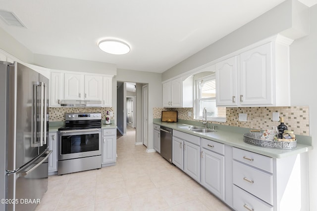 kitchen with white cabinetry, stainless steel appliances, tasteful backsplash, light tile patterned flooring, and sink