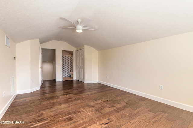 interior space featuring a textured ceiling, dark hardwood / wood-style flooring, ceiling fan, and lofted ceiling