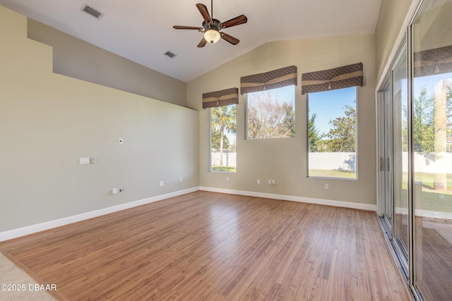 empty room with ceiling fan, light wood-type flooring, and vaulted ceiling