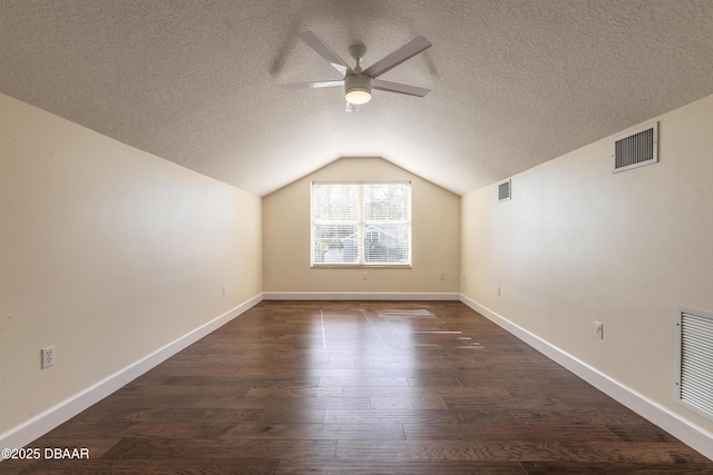 bonus room with ceiling fan, dark hardwood / wood-style floors, lofted ceiling, and a textured ceiling